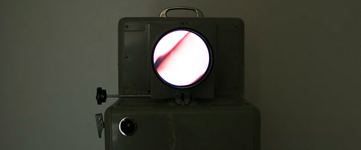 A dated projection machine features an image of the artist's throat.
