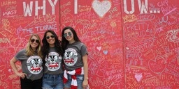 Three WASB students in front of &quot;Why I heart UW&quot; graffiti board