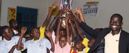 Ugandan students hold up a trophy after winning a 5 STA-Z tournament.
