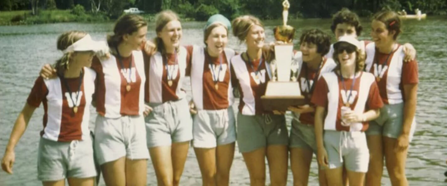 Photo of the varsity eight women's rowing team in 1975 with championship trophy.