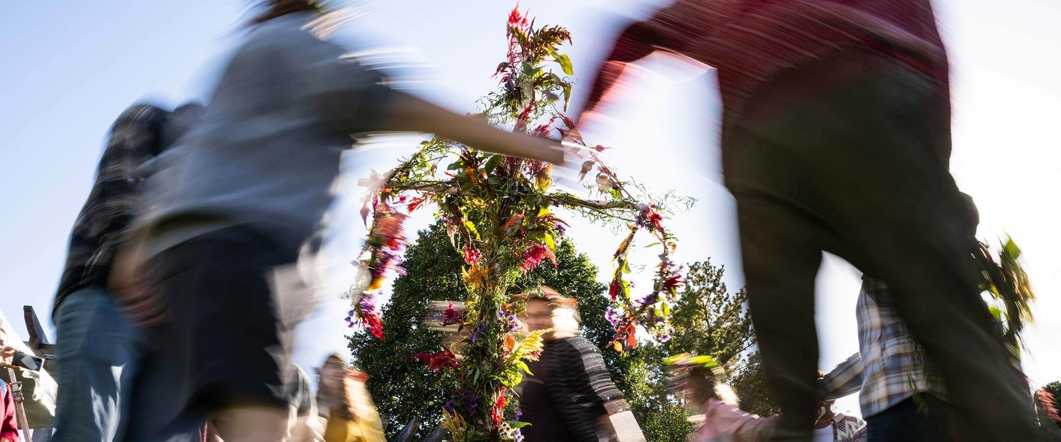 People dance around a maypole.
