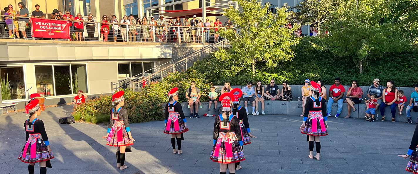 A crowd watches a cultural performance in Alumni Park.