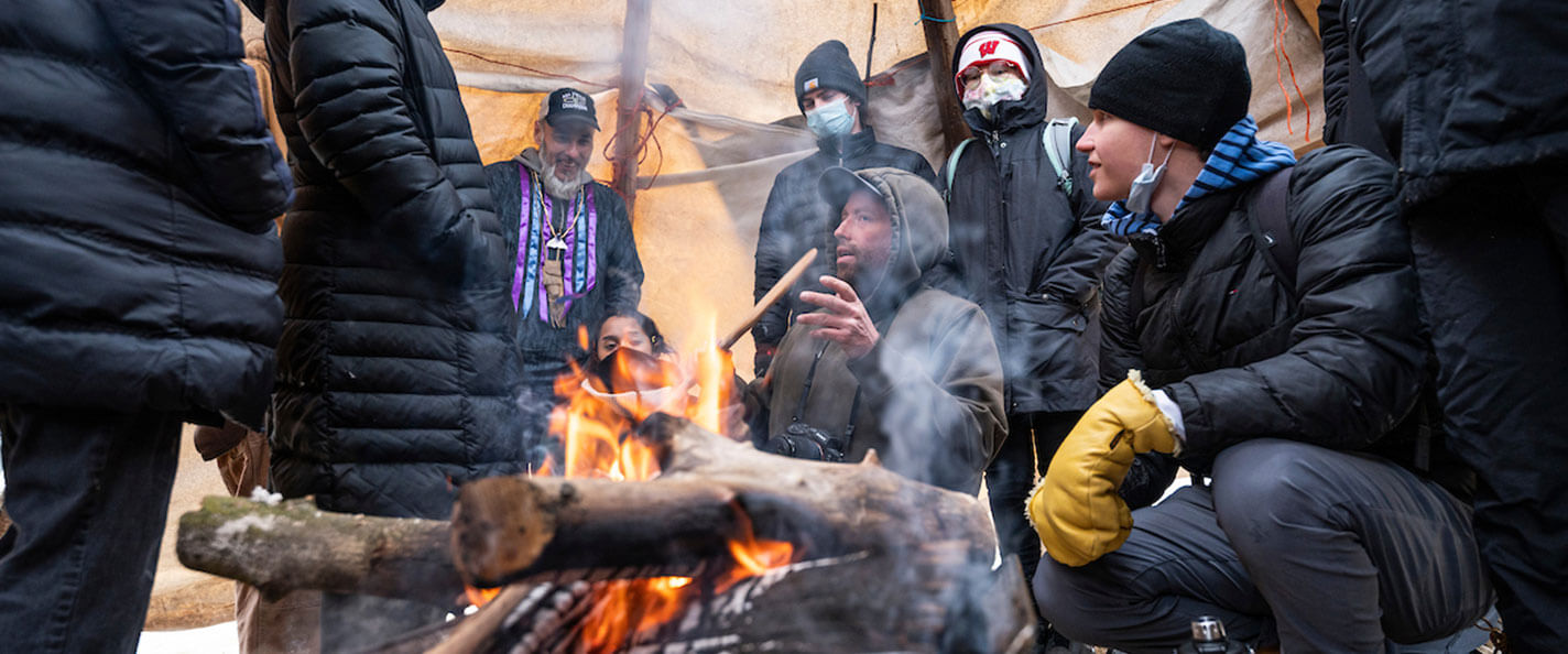 Cornelius teaches students about traditional Indigenous food practices inside a temporary lodge.