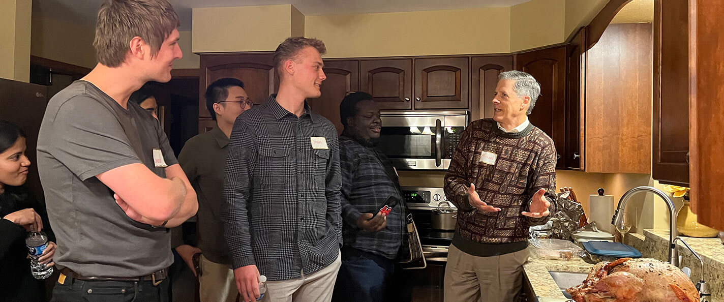 A group of international students standing in a kitchen.