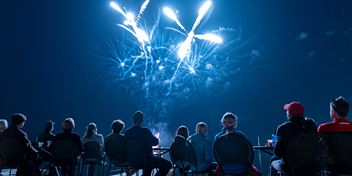 People enjoying fireworks over Lake Mendota from the Memorial Union Terrace