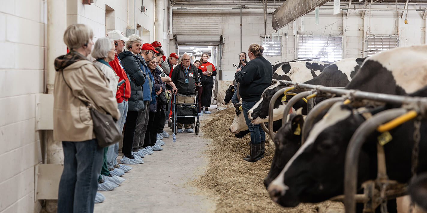 People in a cattle facility listening to a worker speak