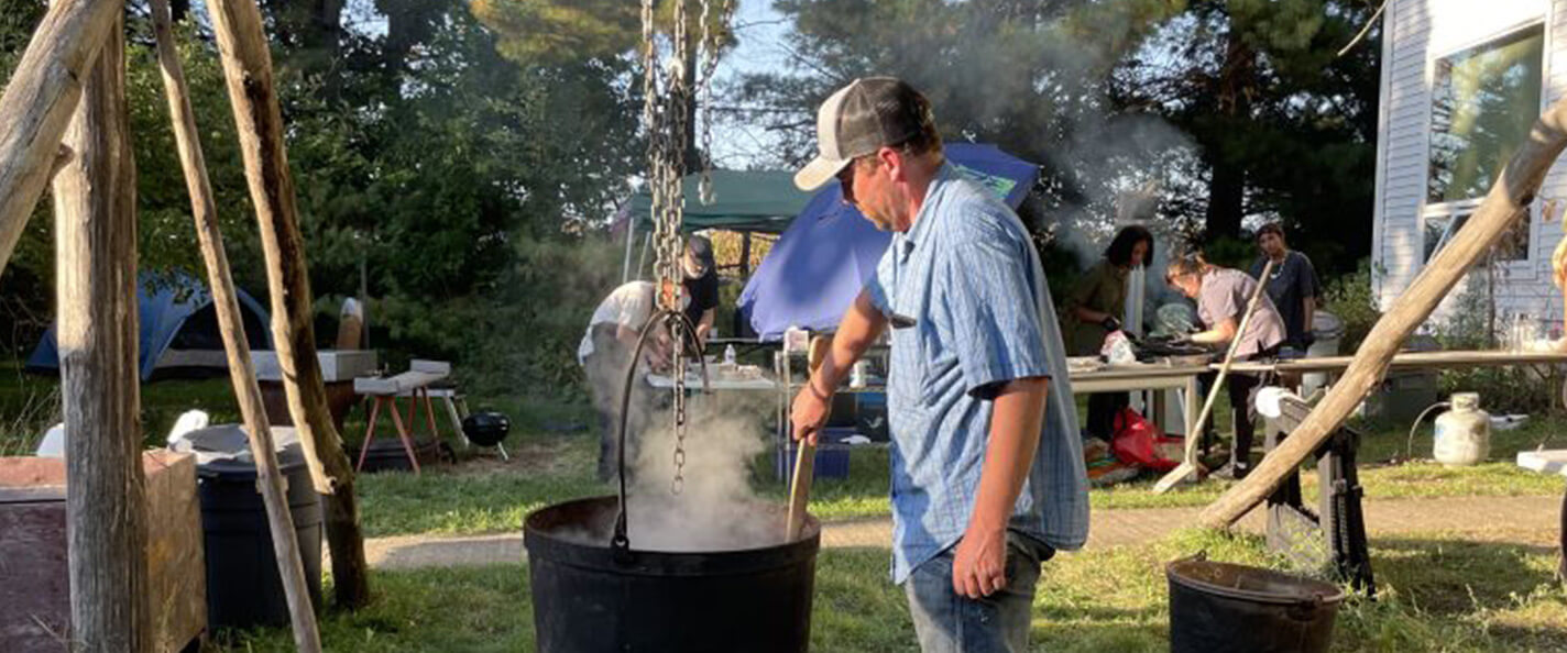 Cornelius cooks over an open fire.