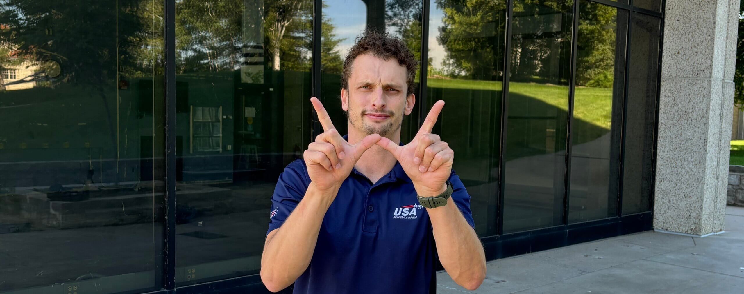 UW ASL instructor Taylor Koss shows the sign for the University of Wisconsin.